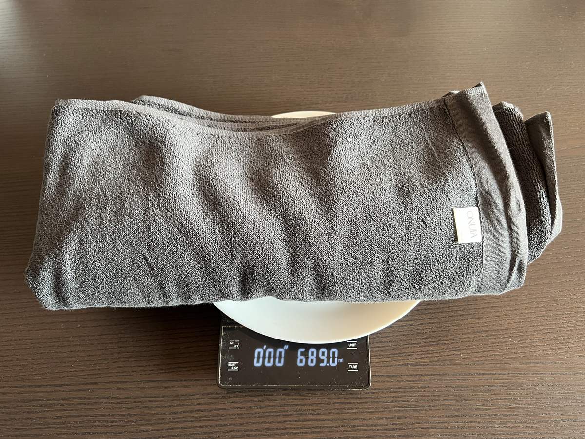 Onuia 800 GSM Heavyweight bath towel on a kitchen scale reading 689 grams