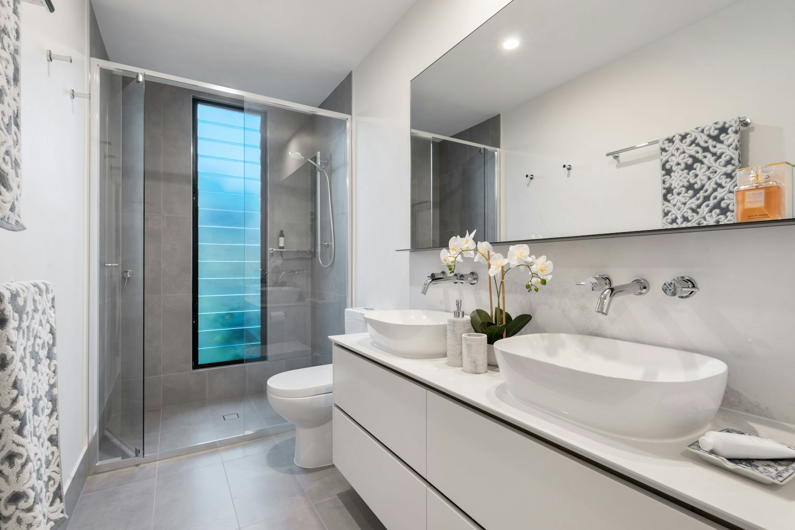 Bright modern bathroom with white cotton towels and a double vanity