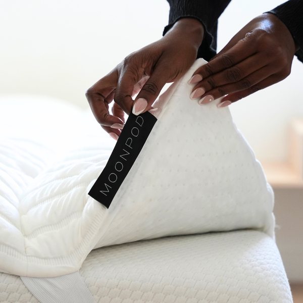 Moon Pod Moon Cloud mattress topper with the corner lifted to show the strap and non-skid base